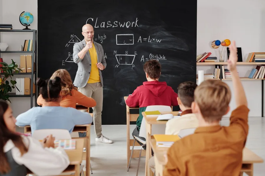 Guru menerangkan pelajaran kepada pelajar dalam kelas