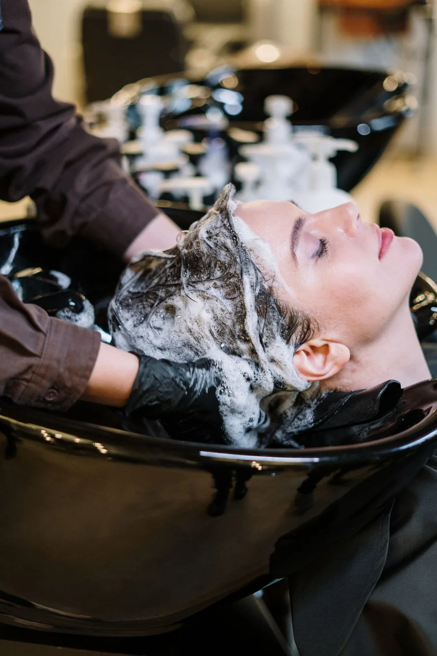 Pelanggan menerima rawatan cucian rambut di salon